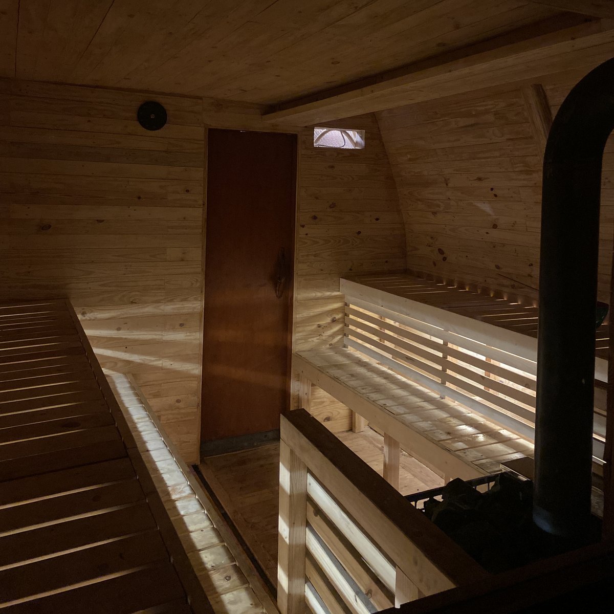 Wood-fired sauna interior bathed in warm light